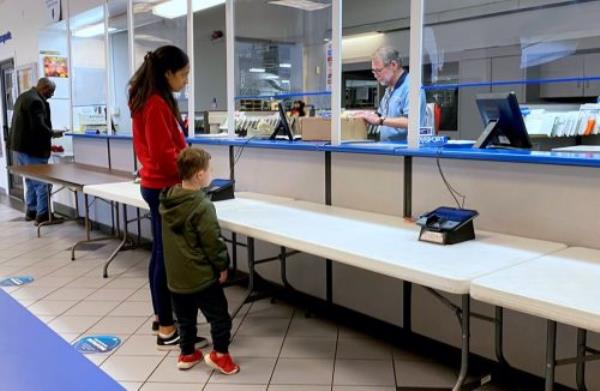 Young woman with child sending mail. Postoffice in Charlottesville, USA