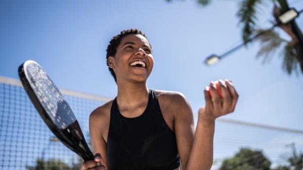 Happy woman celebrating during beach tennis match