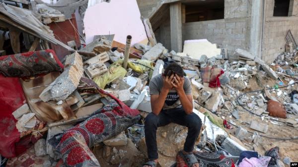 A Palestinian youth reacts as he sits on the rubble of a destroyed home following an Israeli military strike on the Rafah refugee camp, in the southern of Gaza Strip on Oct. 15, 2023.