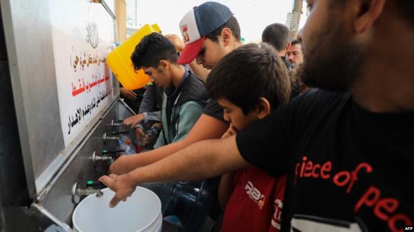 Palestinians line up to fill water cannisters in Gaza City, on Oct. 16, 2023. The United Nations says most people in Gaza have no access to water.