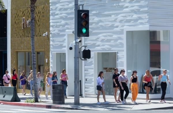BEVERLY HILLS, CA-APRIL 18, 2022: Security cameras are attached on a pole below a traffic signal as pedestrians walk along Rodeo Dr. in Beverly Hills. The city of Beverly Hills has in recent years added hundreds of cameras to its already widespread surveillance network. 
