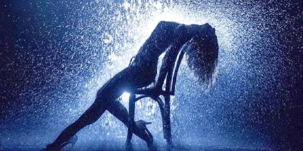 Jennifer Beals rests her chin on her hand in Flashdance