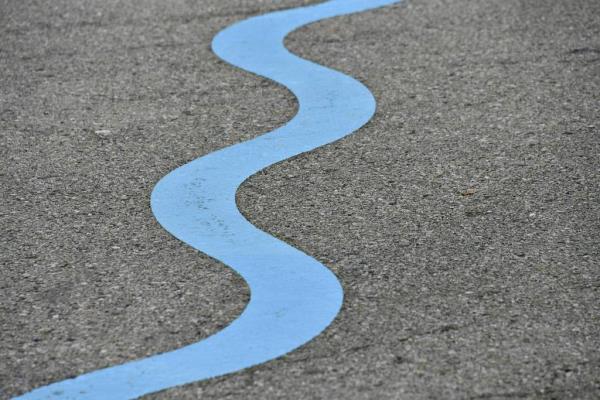 A ribbon of blue snakes across the streets and sidewalks of Remington, part of ruce Willen’s public art installation and neighborhood history walk, “Ghost Rivers.”