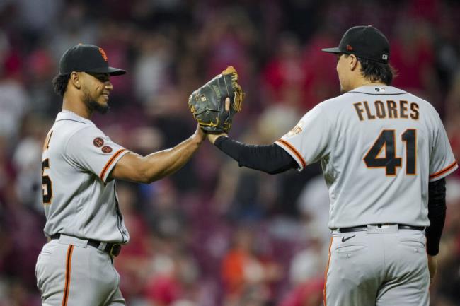 The Giants’ Camilo Doval, left, high-fives Wilmer Flores after the final out against the Reds in Cincinnati, early Wednesday, July 19, 2023. (Aaron Doster / ASSOCIATED PRESS)
