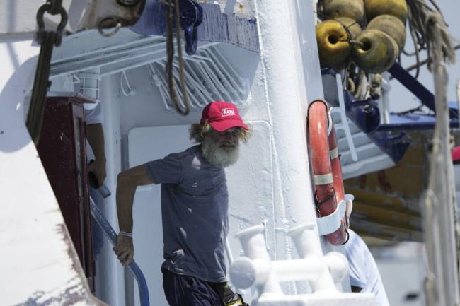 Australian Timothy Lyndsay Shaddock gets off the tuna boat "Maria Delia" that rescued him and his dog Bella, as he arrives to port in Manzanillo, Mexico, Tuesday, July 18, 2023. After being adrift with his dog for three months, the pair were rescued by the Mexican boat from his incapacitated catamaran in the Pacific Ocean some 1,200 miles from land. (AP Photo/Fernando Llano)
