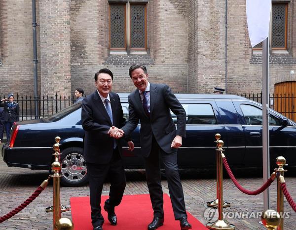President Yoon Suk Yeol (L) shakes hands with Dutch Prime Minister Mark Rutte as he arrives at Rutte's office in The Hague for their summit on Dec. 13, 2023. (Yonhap)