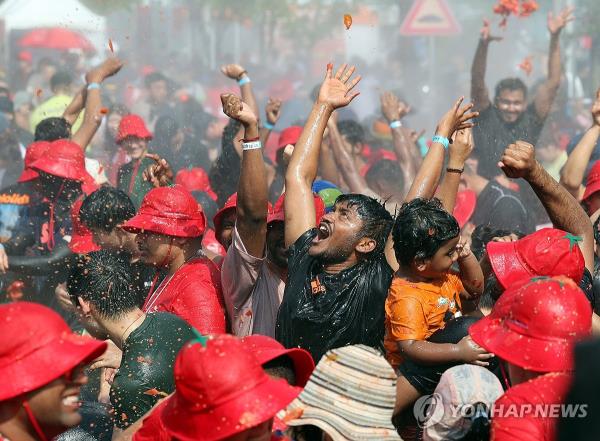 A foreigner enjoys his time in a tomato-filled pool at the Tomato Festival in Hwacheon, Gangwon Province, on Aug. 3, 2024. (Yonhap)