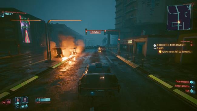 Cyberpunk 2077 Phantom Liberty Screenshot Of Car Driving Towards Burning Cars